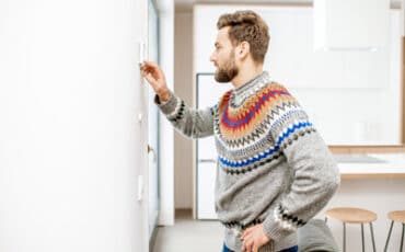 Man adjusting the thermostat temperature