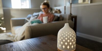 Essential oil diffuser with a woman relaxing on a couch